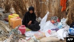 FILE - A Yemeni woman sits in the remains of a home in a neighborhood ravaged by Tropical Cyclone Sagar, in the port city of Hodeidah, Yemen, May 19, 2018. Tropical Cyclone Luban devastated the southeastern coast of Yemen earlier this week.
