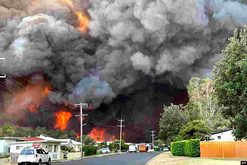 Flames from an out-of-control bushfire are seen from a nearby residential area in Harrington, some 335 kilometers northeast of Sydney, Australia, in this handout photo taken by Kelly-ann Oosterbeek.