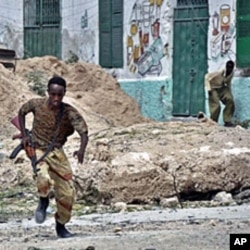 A government soldier runs for cover during heavy clashes in northern Mogadishu between Somali government troops and insurgent forces (File)