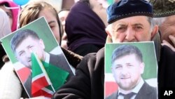 FILE - People hold portraits of Chechen leader Ramzan Kadyrov as they take part in a rally marking the 13th anniversary of the adoption of the Constitution of Russian region of Chechnya, in the regional capital of Grozny, March 23, 2016.