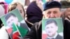 FILE - People hold portraits of Chechen leader Ramzan Kadyrov as they take part in a rally marking the 13th anniversary of the adoption of the Constitution of Russian region of Chechnya, in the regional capital of Grozny, March 23, 2016.