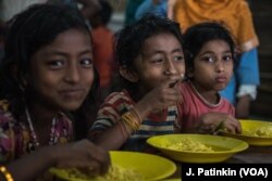 Rohingya refugee children enjoy a free lunch from Action Against Hunger in Ukhiya, Bangladesh, April 19, 2018.