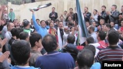 敘利亞示威者在德拉的反阿薩德總統的活動中高舉反對派的旗幟