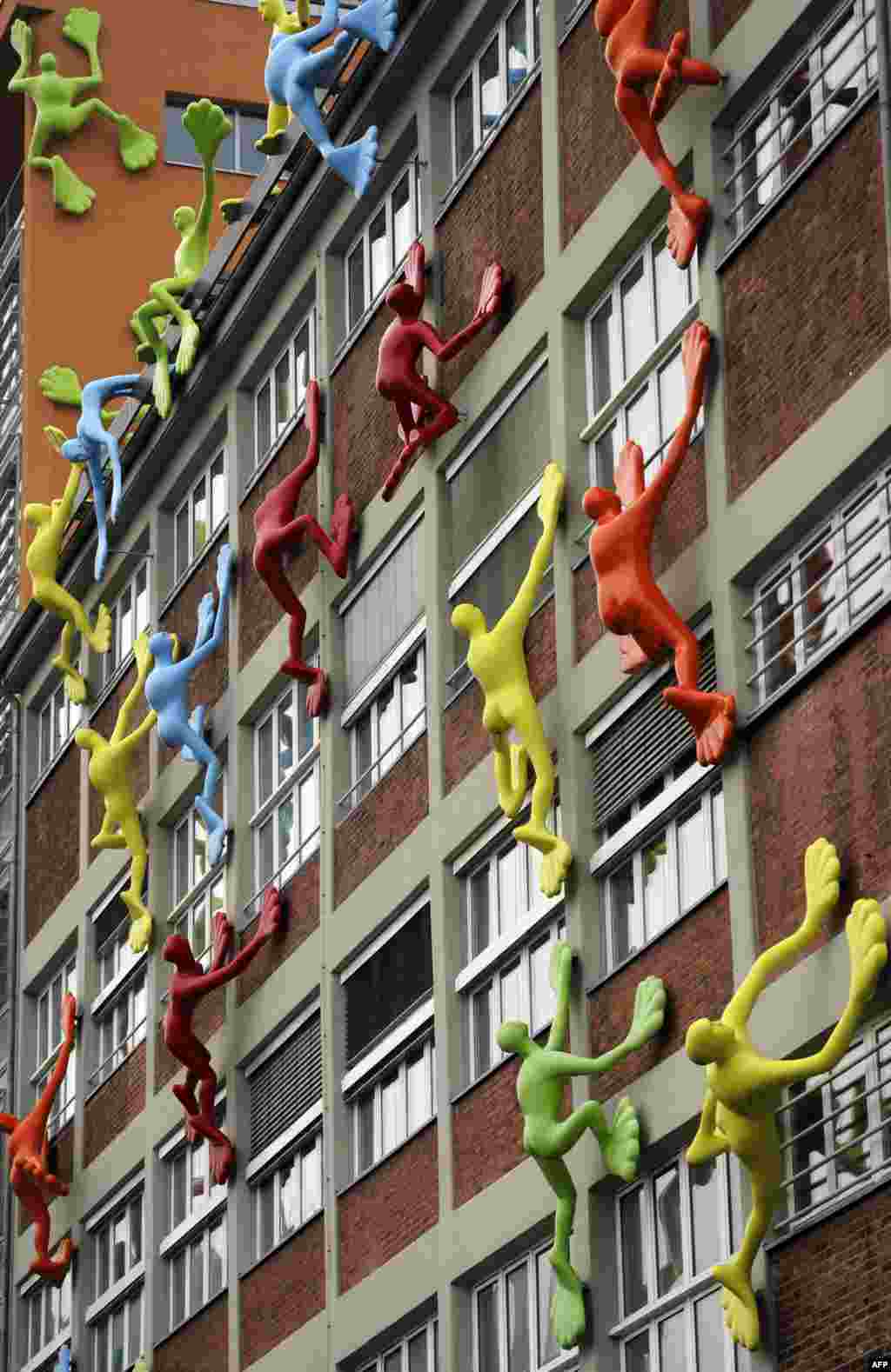 Sculptures called &#39;Flossis&#39; by German artist Rosalie seem to climb a building in Duesseldorf, western Germany, January 8, 2013. The installation consists of 29 sculptures, each measuring 4,20 m high and 2,50 m wide. 