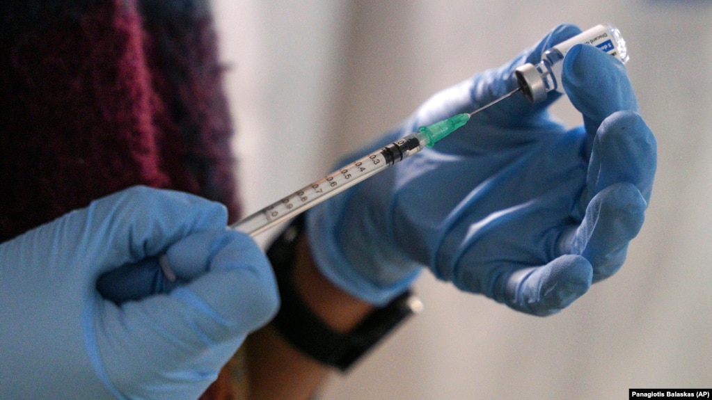 An employee from the National Health Organization (EODY) prepares a Johnson and Johnson vaccine against COVID-19 at Karatepe refugee camp, on the northeastern Aegean island of Lesbos, Greece, on December 15, 2021. (AP Photo/Panagiotis Balaskas, File)