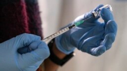 An employee from the National Health Organization (EODY) prepares a Johnson and Johnson vaccine against COVID-19 at Karatepe refugee camp, on the northeastern Aegean island of Lesbos, Greece, on December 15, 2021. (AP Photo/Panagiotis Balaskas, File)