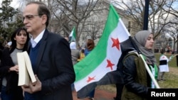 Chief Syrian Opposition Coalition negotiator Hadi al-Bahra (L) awaits his turn to address dozens of protestors gathered to mark the third anniversary of the Syrian revolution, in Lafayette Park, across from the White House in Washington, March 15, 2014.