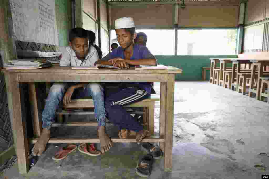 Rohingya refugees Shaiful Islam (L) and Mohammed Rohim, both 14, read passages in a class at Kutupalong camp Mar. 31, 2019. (Hai/Do)
