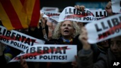 Demonstrators gather during a protest calling for the release of Catalan jailed politicians, in Barcelona, Spain, Nov. 11, 2017. Eight members of the now-defunct Catalan government remain jailed in an alleged rebellion case. The banners read in Catalan: "Freedom for the political prisoners."