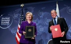 FILE - U.S. Secretary of State Hillary Clinton (L) and Russia's Foreign Minister Sergey Lavrov pose after signing the Plutonium Disposition Protocol during a ceremony at the Washington Convention Center in Washington, April 13, 2010.