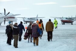 스티븐 딜링엄 인구조사국 국장과 인구 조사원들이 21일 알래스카주 톡숙베이 지역으로 가는 비행기에 탑승하기 위해 이동하고 있다.