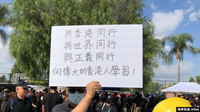 “全球反独裁集会”洛杉矶巴恩斯公园力挺香港活动中，一名自称移居中华民国的男子举牌支持香港