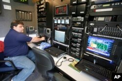Dave Houchins, un especialista en telecomunicaciones de FEMA, en el control un Vehículo de Respuesta Inicial de la agencia durante inundaciones repentinas en Waterbury, Vermont, en agosto de 2008.