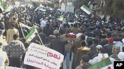 Demonstrators protest against Syria's President Bashar al-Assad after Friday prayers, with banners that read, 'Yes to support the Free Army,' in Al Qusour, Homs, Syria, March 2, 2012.

