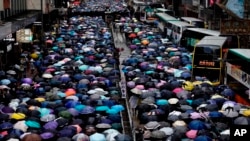 မိုးရွာထဲ ထီးဆောင်းပြီး ဆန္ဒပြနေကြသည့် ဟောင်ကောင် ဒီမိုကရေစီရေး လှုပ်ရှားသူများ။ (အောက်တိုဘာ ၆၊ ၂၀၁၉)