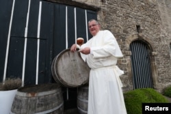 Norbertine Father Karel poses with a Grimbergen beer in the courtyard of the Belgian Abbey of Grimbergen before announcing that the monks will return to brewing, in Grimbergen, Belgium May 21, 2019. REUTERS/Yves Herman