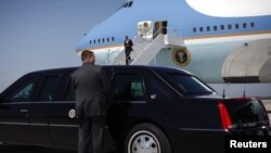 Un agente del Servicio Secreto abre la puerta de la limosina mientras el presidente Barack Obama arriba al aeropuerto de Cleveland.