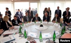 FILE - Brian Fishman, third from left, the head of counterterrorism policy at Facebook, and other representatives from Google, Microsoft and Twitter meet with G-7 interior ministers to discuss efforts in combating extremism on the internet during a Group of Seven meeting in Italy, Oct. 20, 2017.