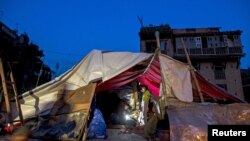 FILE - Local residents gather inside their temporary makeshift shelter after a fresh 7.3 earthquake struck, in Bhaktapur, Nepal, May 2015.