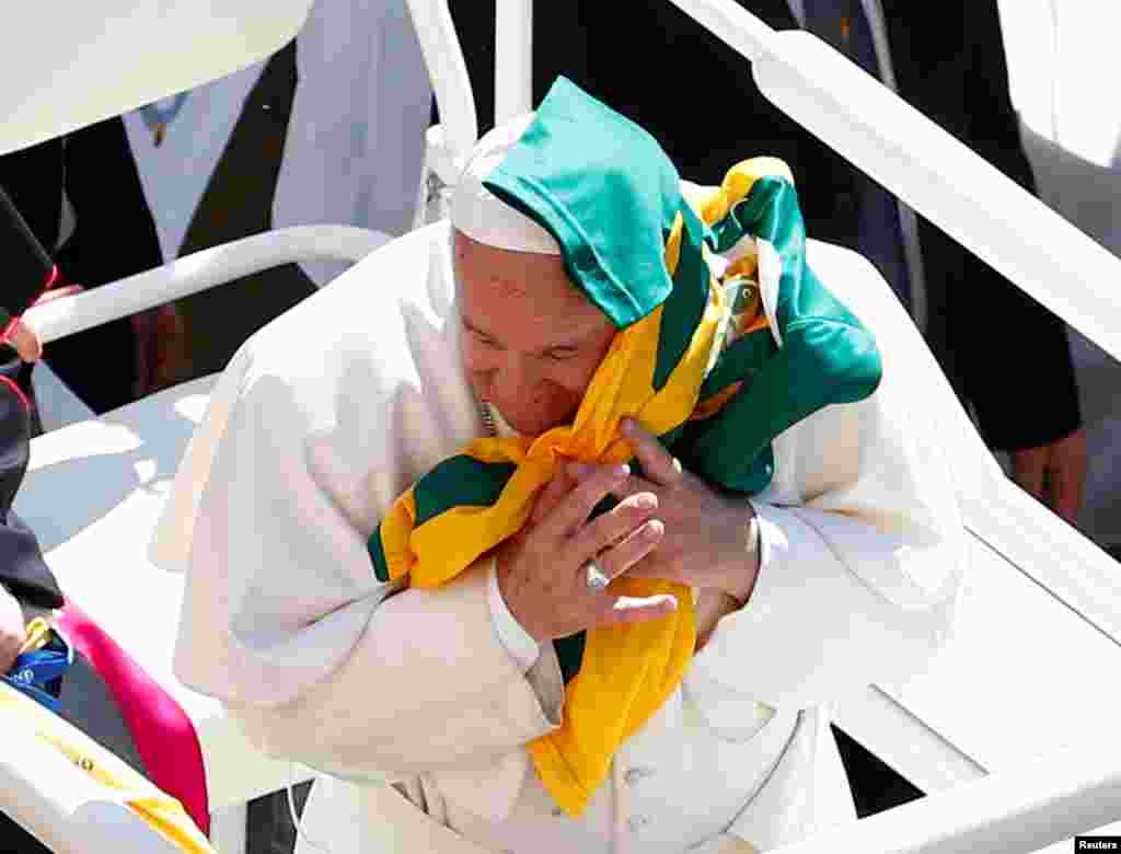 A yellow and green jersey is thrown to Pope Francis as he waves to the faithful during a visit to the Shrine of Our Lady of Loreto on the feast of the Annunciation, in Loreto, Italy.