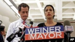 Anthony Weiner, left, listens as his now estranged wife, Huma Abedin, speaks at a news conference during his mayoral campaign in New York, July 23, 2013. Abedin is one of Hillary Clinton's top aides.