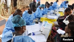 FILE - Congolese health workers register people and take their temperatures before they are vaccinated against Ebola in the village of Mangina in North Kivu province of the Democratic Republic of Congo, Aug. 18, 2018.