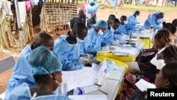 ARCHIVO - Trabajadores de salud congoleses inscriben a pacientes y les toman la temperatura antes de vacunarlos contra el ébola en la aldea de Mangina, provincia de Kivu, República Democrática del Congo. 18-8-18.