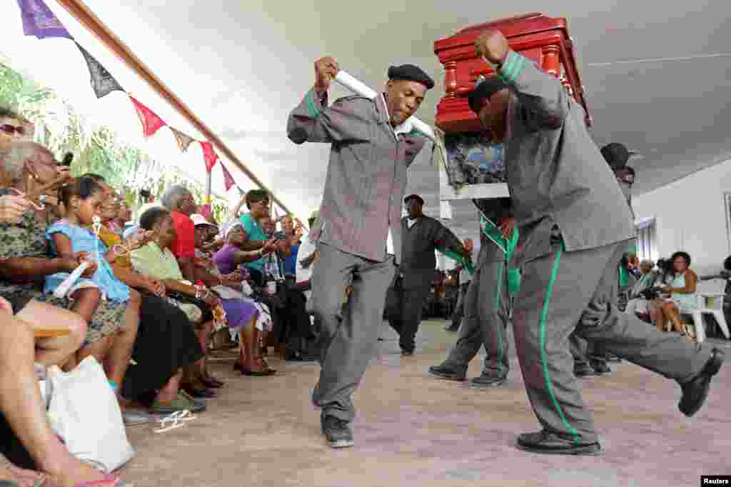 Pallbearers from one of the Surinamese capital&#39;s cemeteries dance and sing with a casket during a competition for best performing pallbearers group at the Hodie Mi Cras Tibi funeral hall in Paramaribo, Sept. 20, 2015.