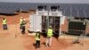 Des techniciens sur un site de production d'énergie photovoltaïque à Bokhol, au Sénégal, le 22 octobre 2016. C’était l’un des plus grands projets d'énergie solaire d'Afrique subsaharienne. (Photo de SEYLLOU / AFP)