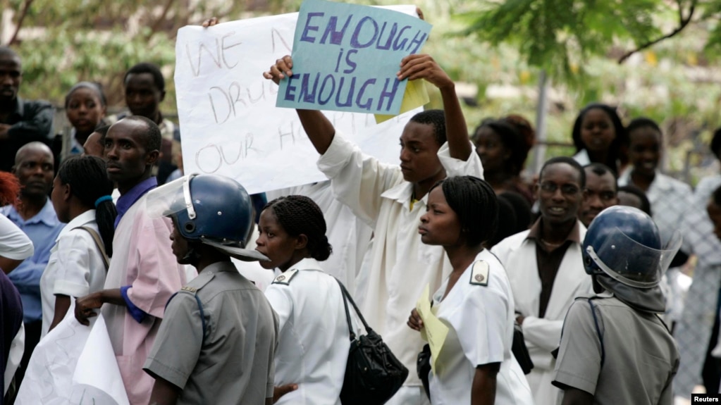 FILE - Zimbabwean riot policemen stand in front of doctors and nurses who are demonstrating over the deteriorating health system, outside Parirenyatwa group of hospitals in Harare, Nov. 18, 2008.