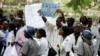 FILE - Zimbabwean riot police officers stand in front of doctors and nurses demonstrating over the deteriorating health system, outside Parirenyatwa public hospitals in Harare, Nov. 18, 2008.
