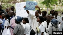 Médecins et infirmières lors d'une manifestation contre la détérioration du système de santé en présence de policiers anti-émeutes à Harare, Zimbabwe, le 18 novembre 2008.