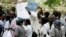 FILE - Zimbabwean riot policemen stand in front of doctors and nurses who are demonstrating over the deteriorating health system, outside Parirenyatwa group of hospitals in Harare, Nov. 18, 2008.