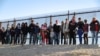 FILE - A group of Central American migrants surrenders to U.S. Border Patrol Agents south of the U.S.-Mexico border fence in El Paso, Texas, March 6, 2019.