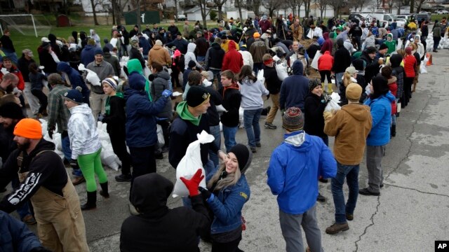 Voluntarios de St. Louis, Missouri ayudan a llenar sacos de arena para contener las inundaciones. Dic. 29, 2015
