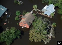 A home sits in floodwaters in Nichols, South Carolina, Oct. 10, 2016. Nearly 1 million homes and businesses still did not have power Monday morning in the Carolinas after Hurricane Matthew.
