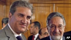 Pakistan's Foreign Minister Shah Mahmood Qureshi (L) poses with his Afghan counterpart Zalmai Rassoul before their meeting in Islamabad, Jan. 27, 2011.