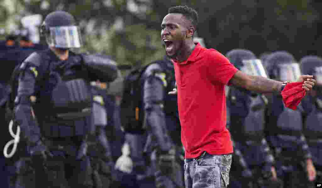 Seorang demonstran meneriaki polisi di depan kantor polisi Baton Rouge setelah polisi tiba dalam perlengkapan anti-huru-hara untuk mengusir pemrotes di Baton Rouge, Louisiana (9/7). (AP/Max Becherer)