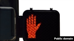 A pedestrian light displays the red symbol for "Don't walk."