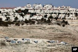 The Israeli settlement of Maaleh Adumim looms over Arab Bedouin shacks in the West Bank, Jan. 22, 2017.
