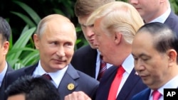 FILE - Russian President Vladimir Putin and U.S. President Donald Trump talk as they arrive for the family photo session during the APEC summit in Danang, Vietnam, Nov. 11, 2017.