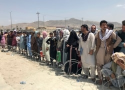 Cientos de personas se reúnen frente al aeropuerto internacional en Kabul, Afganistán, el martes 17 de agosto de 2021.