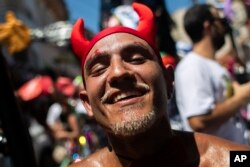 FILE - A reveler dressed as a devil attends the Carmelitas street party on the first day of Carnival in Rio de Janeiro, Brazil, February. 9, 2024