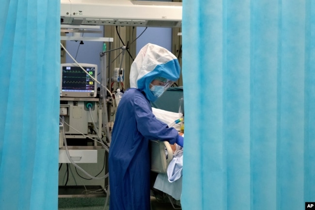 Seorang nakes tengah merawat seorang pasien di dalam unit perawatan intensif COVID-19 di Rumah Sakit Poliklinik Tor Vergata di Roma, Italia, 13 Desember 2020.