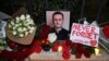 Para pengunjuk rasa meletakkan bunga duka cita di depan bekas gedung kedutaan Rusia di Tbilisi, setelah pengumuman meninggalnya kritikus terkemuka Kremlin, Alexey Navalny di penjara Arktik, 16 Februari 2024. (Vano SHLAMOV / AFP)