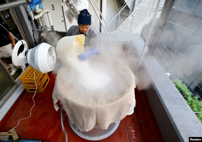 Yoshimi Terasawa, chief brewer at Tokyo Port Brewing, works to steam rice as a part of brewing sake, traditional rice wine, at the brewery in Tokyo, Japan July 9, 2024. (REUTERS/Kim Kyung-Hoon)