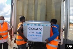FILE - Workers load boxes of Oxford/AstraZeneca COVID-19 vaccines, part of the COVAX program, into a truck after they arrived by plane at the Ivato International Airport in Antananarivo, Madagascar, May 8, 2021.