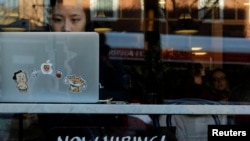 FILE - A "Now Hiring" sign sits in the window of Tatte Bakery and Cafe in Cambridge, Massachusetts, Feb. 11, 2019.