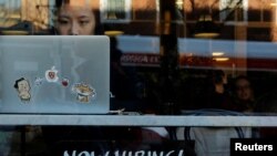 FILE - A "Now Hiring" sign sits in the window of Tatte Bakery and Cafe in Cambridge, Massachusetts, Feb. 11, 2019.