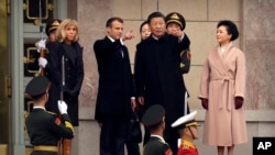French President Emmanuel Macron, second from left, and Chinese President Xi Jinping, second from right, talk on the steps of the Great Hall of the People during a welcome ceremony in Beijing, Nov. 6, 2019. 